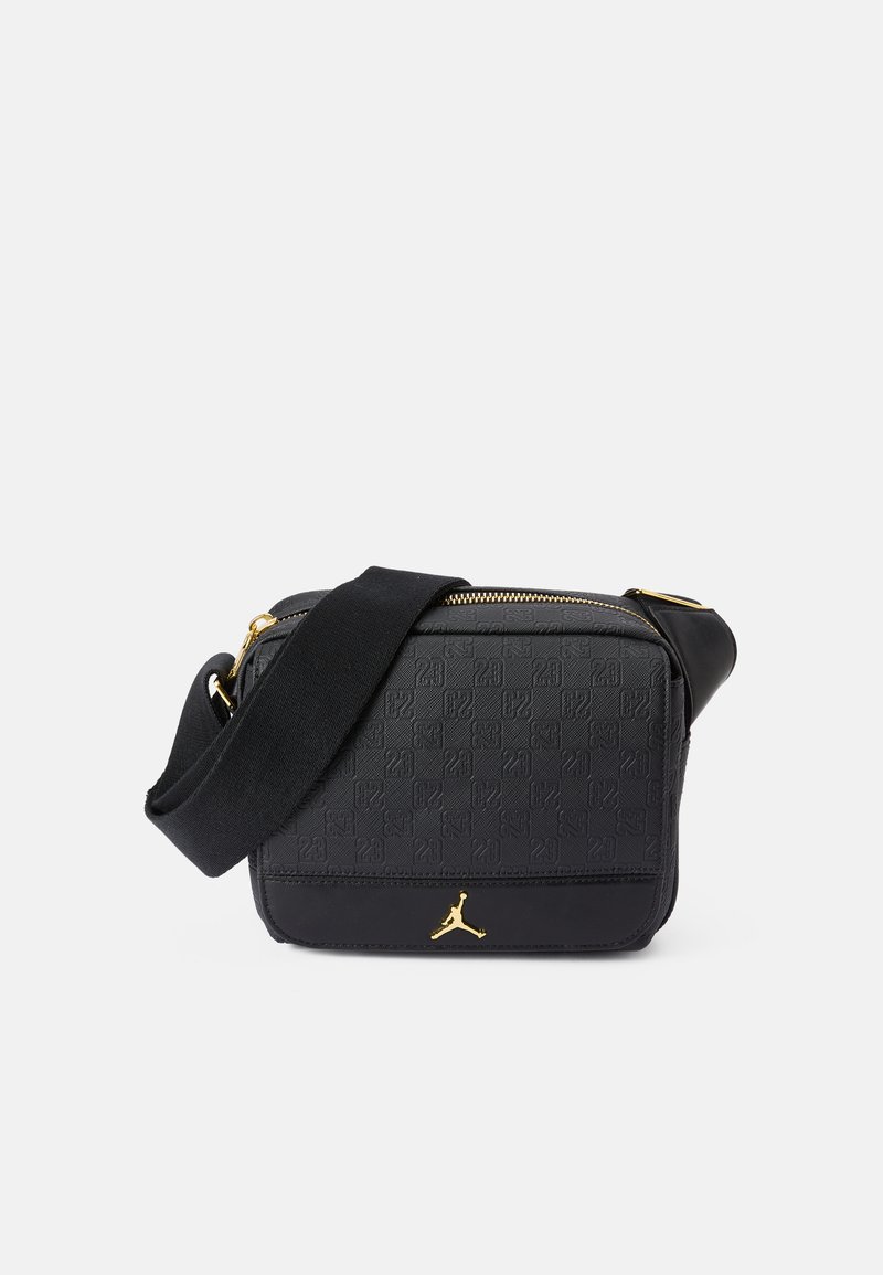 Black crossbody bag featuring a textured pattern, gold hardware accents, and a durable strap. Compact rectangular shape with zip closure.