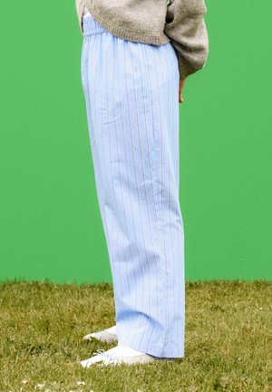 Pantalon rayé bleu clair avec une taille élastique, doté de fines rayures verticales blanches et rouges et d'une coupe droite et décontractée.