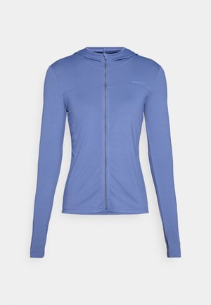 Haut à manches longues, avec fermeture éclair à l'avant, en tissu bleu clair. Présente un motif texturé et une coupe ajustée avec une capuche.