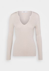 Béžové žebrované tričko s dlouhým rukávem a hlubokým výstřihem do V. Měkká textura a přiléhavý střih. Na límci viditelná značka "NA-KD".