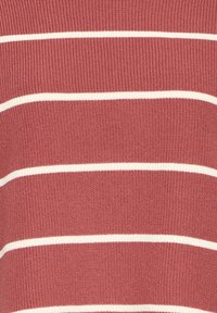 Gros plan sur un tissu rouge tricoté avec des fines rayures horizontales blanches régulièrement espacées.