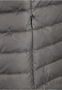 Szara pikowana kurtka puchowa z poziomymi przeszyciami i małym czarnym suwakiem jako zapięciem. Wykonana z trwałego materiału syntetycznego.