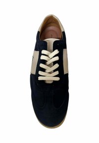 Zapatillas de ante azul marino con detalles en cuero crema, que cuentan con una puntera redondeada, cordones planos y una suela de goma marrón clara.