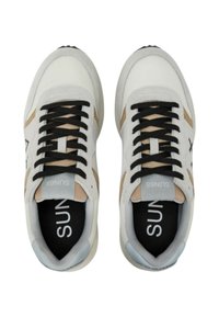 Sneakers bianchi con lacci neri, accenti beige e tessuto strutturato. Punta arrotondata, colletto imbottito e logo sulla linguetta.