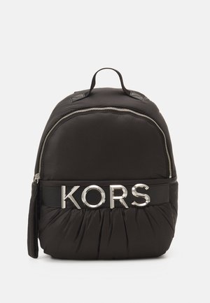 Sac à dos noir en nylon de forme arrondie, fermeture éclair argentée et bande de logo contrastante avec "KORS" en lettres majuscules. Base texturée et froncée.