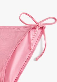 Różowe bikini z gładką fakturą, regulowanym wiązaniem z jednej strony oraz zszytymi krawędziami dla pewnego dopasowania.