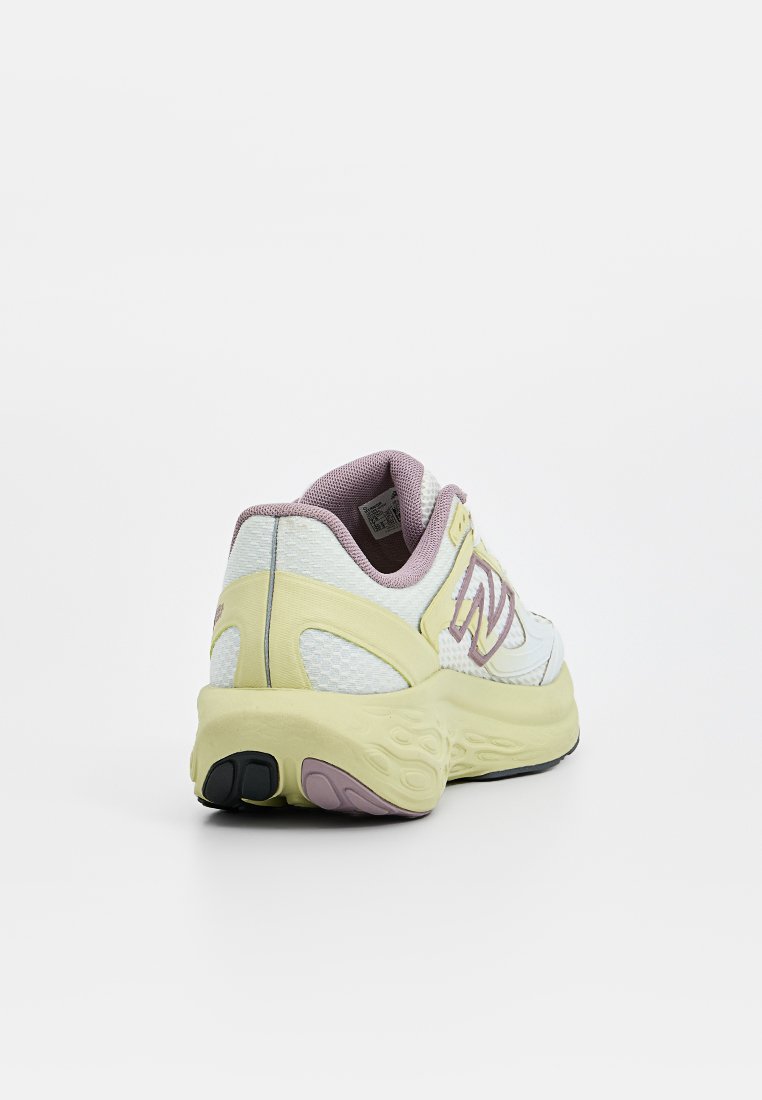 Zapatilla de correr blanca y amarillo claro con una parte superior de malla texturizada, detalles en púrpura y una suela acolchada que presenta un patrón único.