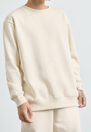 T-shirt-stil sweatshirts i blødt cremefarvet stof, med rund hals, lange ærmer, ribbede manchetter og en afslappet pasform med en kant forneden.