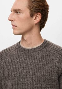 Brązowy prążkowany sweter z okrągłym dekoltem. Charakteryzuje się teksturowaną tkaniną i bezszwowymi ramionami, zapewniając dopasowany, nowoczesny krój.