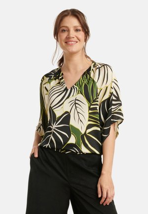 Korte mouwen blouse in lichtgewicht stof met een groen en zwart bladerenpatroon op een crème achtergrond, met een V-hals en een losse fit.