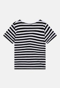 Black and white striped T-shirt made of soft fabric, featuring short sleeves and a round neckline. Design alternates thick and thin stripes.