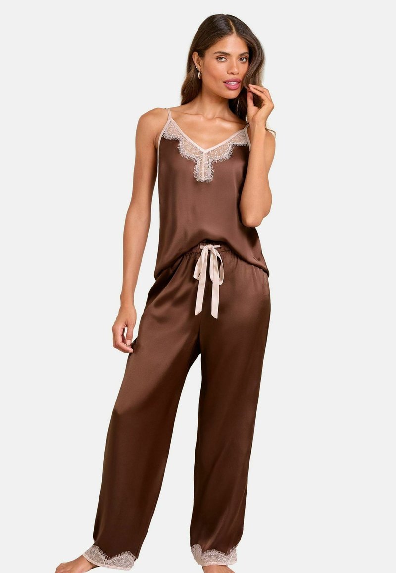 Conjunto de pijama de satén marrón que incluye una blusa sin mangas con ribete de encaje y pantalones con cuerda de ajuste y detalles de encaje en los puños, confeccionados en una tela ligera.