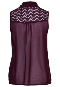 Bordeaux ærmeløs bluse med et tekstureret blondebagstykke med et zigzag-mønster, krave og flydende, semi-gennemsigtig stof.