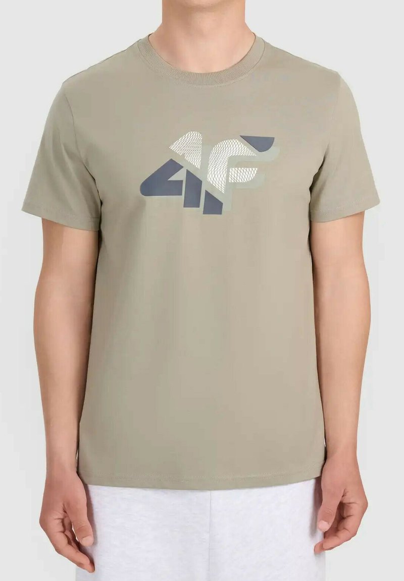 Personne portant un t-shirt beige à manches courtes avec un grand logo "4F" gris et blanc sur la poitrine sur un fond blanc uni.