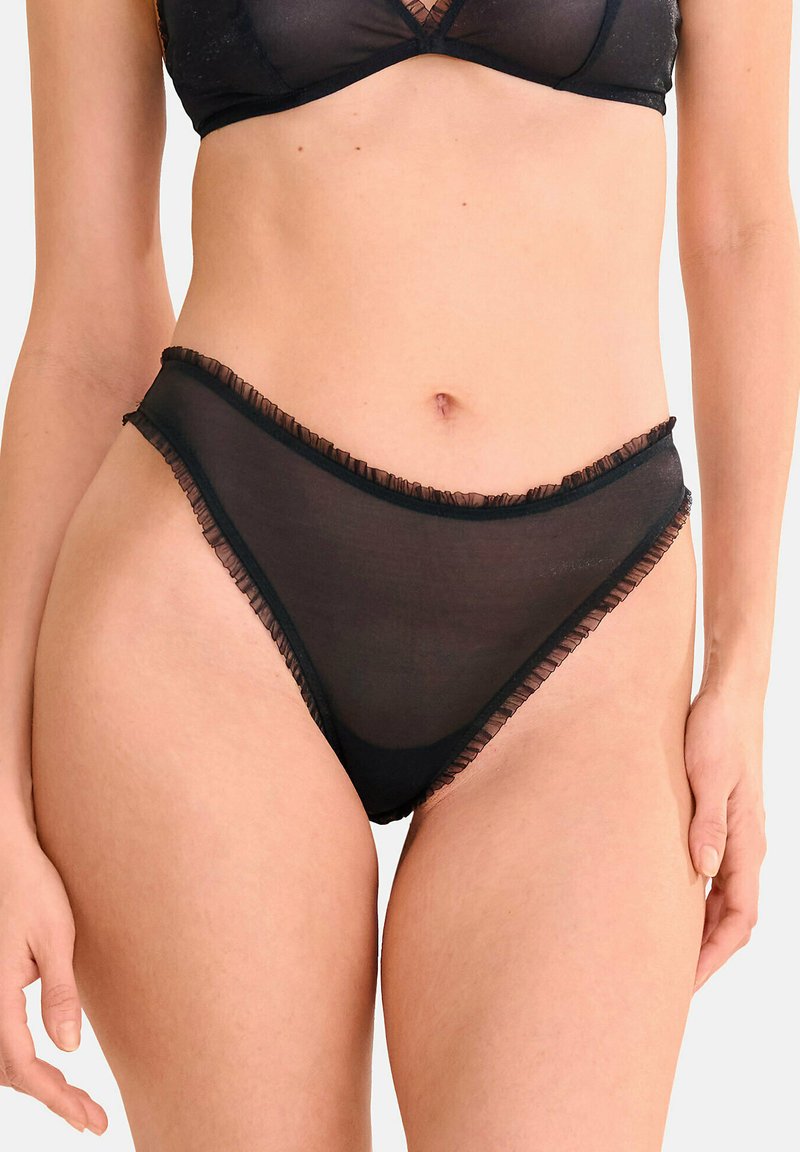 Culotte de bain noire transparente avec bords volantés, présentant un design échancré et une couverture minimale. Tissu doux et léger.