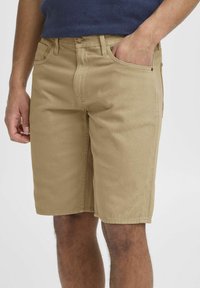 Beige bomulds-shorts med lige snit, der har sidelommer, bæltestropper og en subtil tekstur på stoffet.