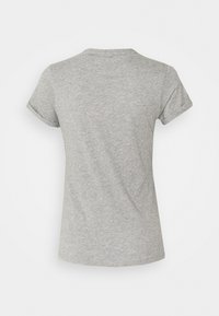 Camiseta de manga corta gris hecha de algodón suave. Presenta un cuello redondo y mangas ligeramente enrolladas. Simple, de color sólido y sin estampados.