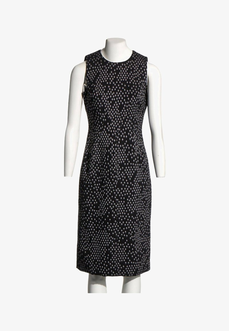Robe noire sans manches longueur genou avec petit motif géométrique blanc en forme de losange, présentée sur un mannequin blanc.