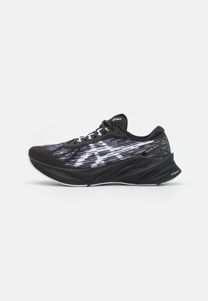 Chaussure de running Asics noire et grise avec empeigne à motif, semelle épaisse et rembourrée, et lacets, vue de côté sur fond blanc.