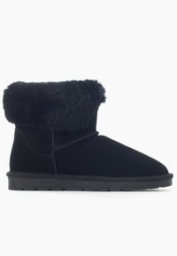 Stivaletto nero realizzato in morbido camoscio con un soffice polsino in pelliccia sintetica. Punta rotonda e suola piatta in gomma con una leggera dettagliatura del battistrada. Cuciture a vista.