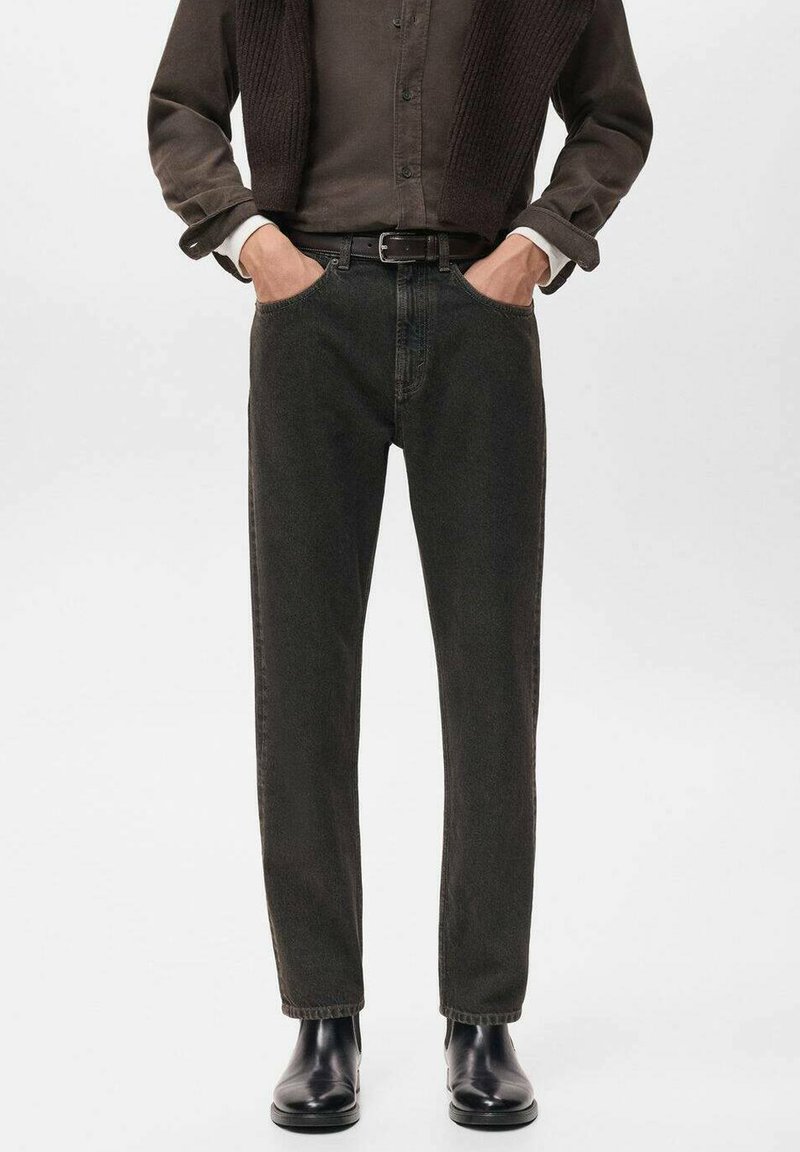 Jeans verde oscuro con un diseño de pierna recta, hechos de denim. Presentan bolsillos laterales y un cinturón, combinados con botas negras hasta el tobillo.