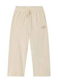 Pantalon de survêtement en polaire beige avec taille élastique à cordon, poches latérales et texte "American Vintage" sur la cuisse gauche.