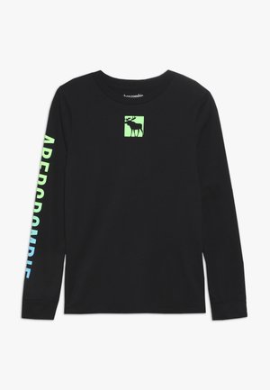 Czarna koszula z długim rękawem z neonowo zielonym logo łosia na piersi oraz napisem „ABERCROMBIE” w gradientzie od zielonego do niebieskiego na prawej rękawie.