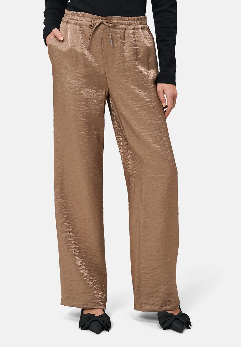 Hosen mit weitem Bein aus metallisch taupefarbenem Stoff, ausgestattet mit einem elastischen Bund mit einem Kordelzug und seitlichen Taschen. Strukturierte Oberflächendetails.