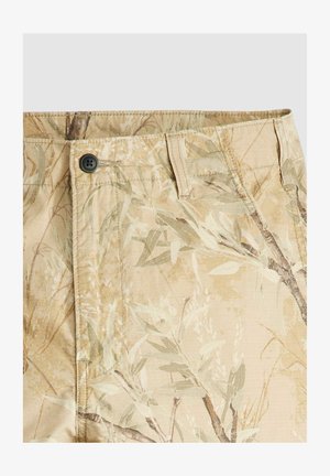 Beige Stoffshorts mit botanischem Muster. Mit Knopfverschluss und sichtbaren Nähten. Das Material hat ein leichtes, strukturiertes Erscheinungsbild.