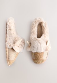 Chaussons beiges duveteux avec accents en forme d'oreilles, tissu à chevrons et doublure en fausse fourrure texturée. Présente des tons naturels et des détails de couture.