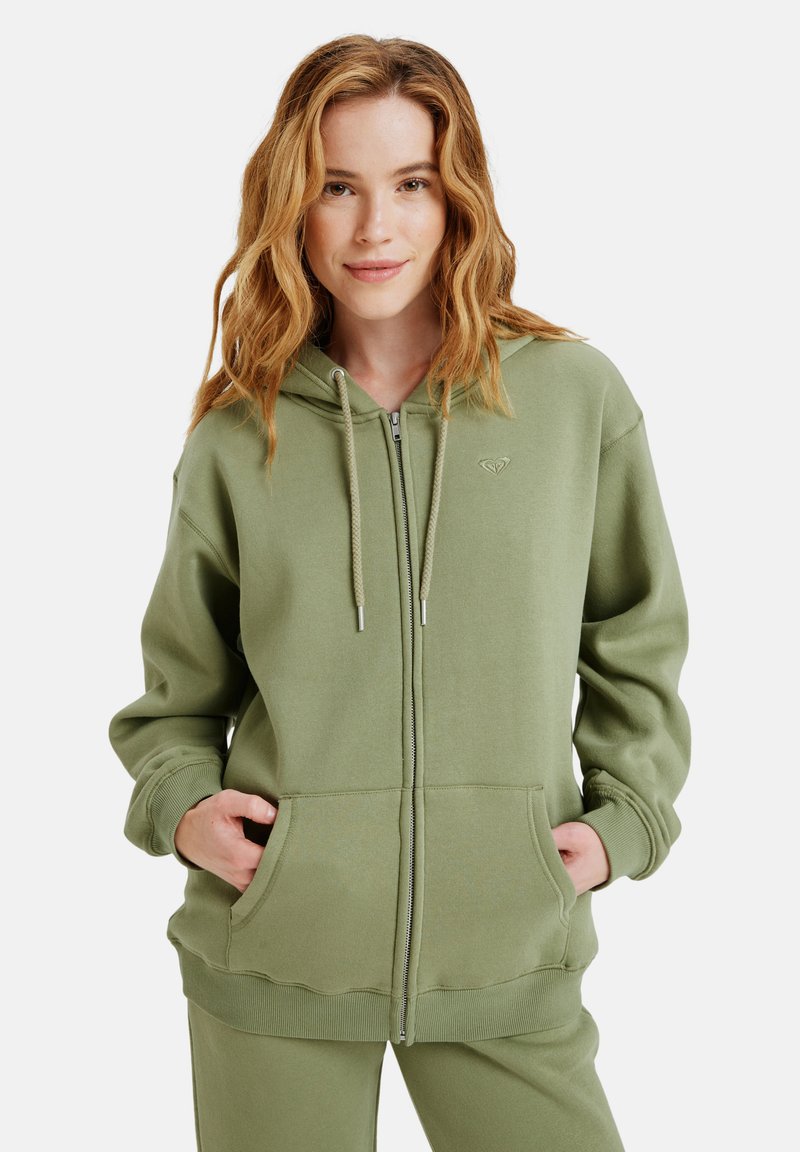 Olivgrüne Zip-Hoodie aus weichem Stoff mit Kapuze, zwei Fronttaschen und gerippten Bündchen und Saum. Dezentes Logodetail vorhanden.