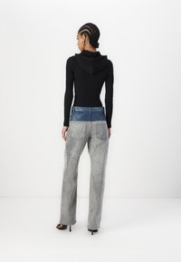 Mustru pikkade varrukatega must siidpehme topp kapuutsiga, kombineeritud heledate hallide teksadega, millel on sinine vöökoht ja tekstureeritud viimistlus. Mustad avatud varvastega kontsad.