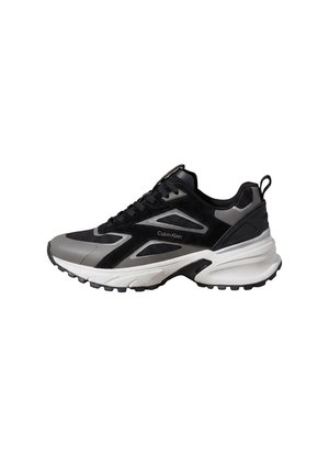 Czarno-szary sportowy sneaker z białą masywną podeszwą, panelami z siateczki i logo Calvin Klein na boku, widziany od zewnętrznej strony.