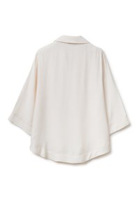Blusa color crema chiaro realizzata in tessuto morbido, con colletto classico, maniche a tre quarti e vestibilità rilassata. Nessun motivo o dettaglio visibile.