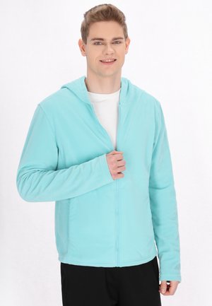 Lichtblauwe fleece zip-up hoodie met een frontzipper, lange mouwen en een capuchon. De textuur is zacht en de pasvorm lijkt losjes. 