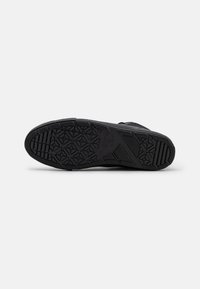 Black sneaker sole, rubber material, textured pattern with geometric shapes, flat design. Features logo and brand name embossed.
