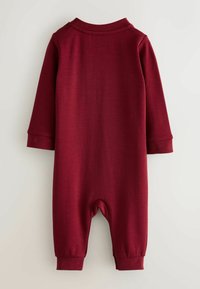 Burgundowy kombinezon dla malucha z długim rękawem, okrągłym dekoltem i elastycznymi mankietami. Gładka tekstura i casualowy design, idealny na codzienne noszenie.