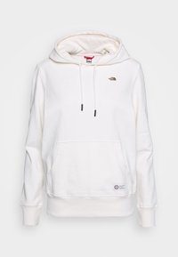 Sudadera blanca hecha de material suave, con un bolsillo frontal, capucha con cordón y un pequeño logo marrón en el pecho. Puños y dobladillo acanalados.