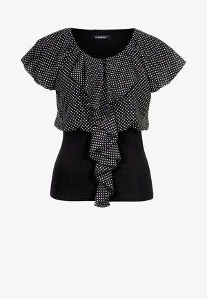 Musta lyhythihainen pusero, jossa on valkoiset pilkulliset röyhelöt päällä ja laskostuva etuosa.