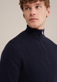 Navyblauer Pullover mit Reißverschluss am Hals, aus strukturiertem Strickstoff, mit hohem Kragen und einem mittellangen Reißverschluss am Hals.