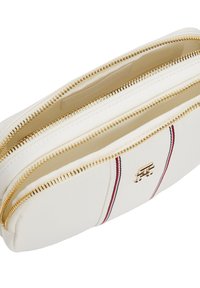 Borsetta bianca con zip e accessori dorati, caratterizzata da una striscia rossa e blu. Texture liscia con un logo in evidenza sulla parte anteriore e interni spaziosi.