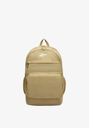 Beżowy plecak z przednimi kieszeniami na zamek, bocznymi siateczkowymi kieszeniami, górną rączką oraz białym logo Reebok na gładkiej tkaninie.