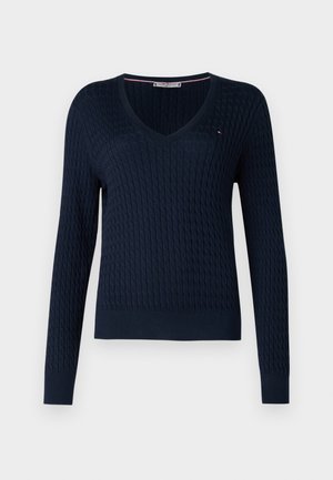 Pull à col en V bleu marine avec manches longues, design en tricot torsadé texturé, poignets et ourlet côtelés, avec un petit logo accent près du col.