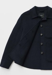 Navy wool-blend jacket with a collared neckline, four buttons, and a chest pocket. Features a textured fabric and tailored silhouette.