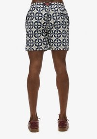 Pantalones cortos de marinero con un patrón floral en crudo, cinturilla elástica y bolsillos laterales. Tela texturizada con un corte relajado.