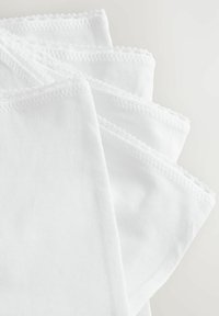 Witte katoenen servetten gestapeld, met een gladde textuur en delicate scalloped randafwerkingen.
