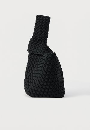 Sac à main noir tissé avec un design asymétrique, présentant une surface texturée et une poignée haute et étroite. Aucune ferrure ou accent visible.
