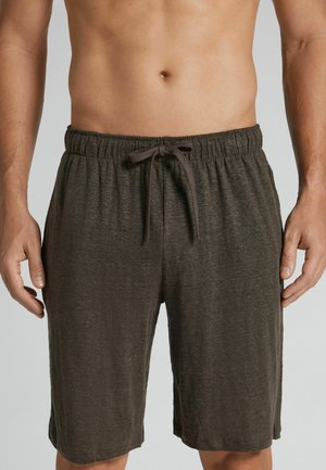 Mand iført mørkegrå shorts med snøre, der står med hænderne afslappet langs siden mod en neutral baggrund.