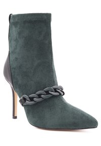 Stivaletto verde in suede con punta a punta, tacco in pelle nera e dettaglio a catena spessa sulla parte superiore. Design con tacco a stiletto.