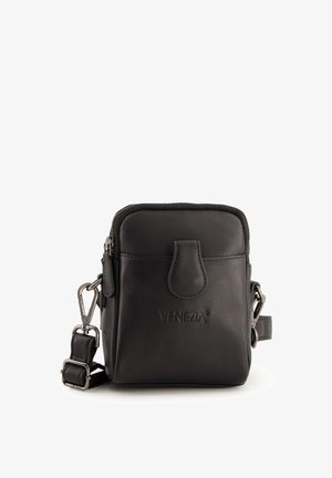 Černá kožená crossbody taška se zipovým uzávěrem, přední klopou a logem. Nastavitelný popruh a kovové akcenty zvyšují funkčnost.